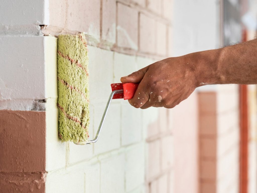 keimwerk wordt met roller op muur aangebracht